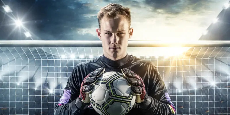 Fußballspieler hält Ball in der Hand
