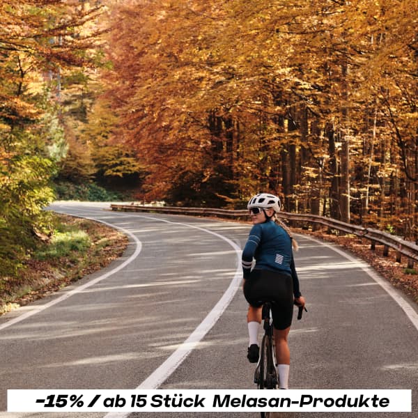 Fahrradfahrerin auf einer Straße im Herbst